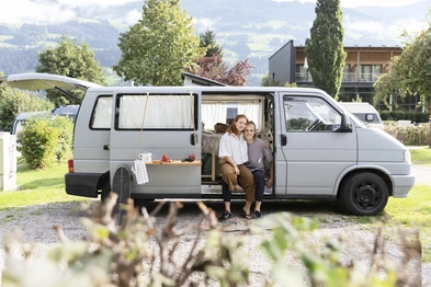 Camping ©Natürlich HELL Camping & Aparthotel Ein Paar in einem grauen Camper auf dem Campingplatz des Natürlich Hell bei schönem Wetter.