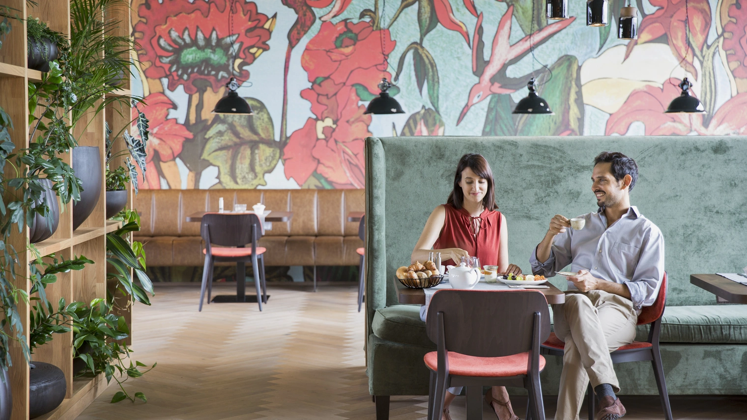 Frühstück ©Natürlich HELL Camping & Aparthotel Zwei Personen die im Frühstücksraum des Camping & Aparthotels an einem fein gedeckten Tisch sitzen, und ihr Frühstück, als einzige im Raum, genießen.