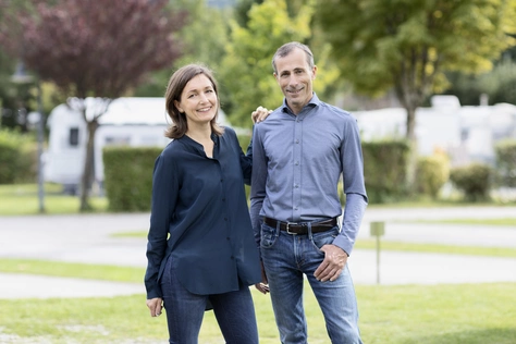 Karin & Alois Hell ©Natürlich HELL Camping & Aparthotel Die Geschäftsführung des Natürlich Hell arm-in-arm mit dem Campingplatz im Hintergrund.