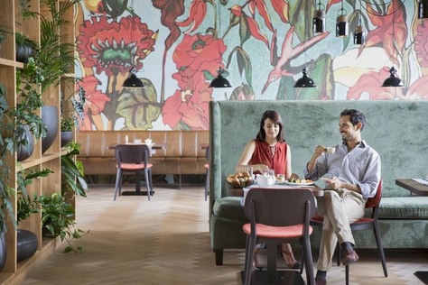 Frühstück ©Natürlich HELL Camping & Aparthotel Zwei Personen die im Frühstücksraum des Camping & Aparthotels an einem fein gedeckten Tisch sitzen, und ihr Frühstück, als einzige im Raum, genießen.